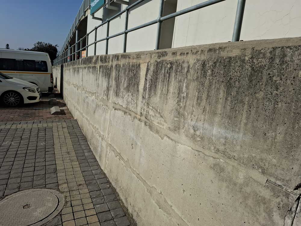 A before image of black efflorescence on concrete walls